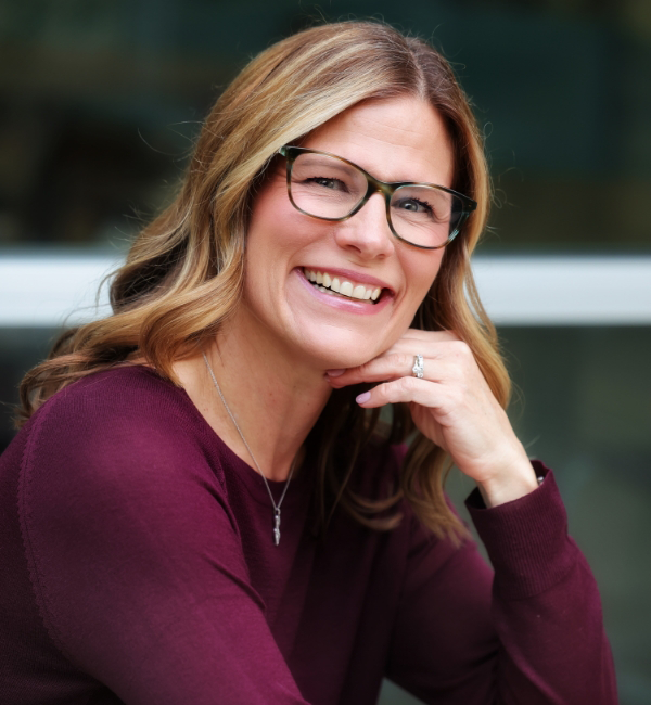 Leadership Coach Ashley Ward with glasses and a maroon top.